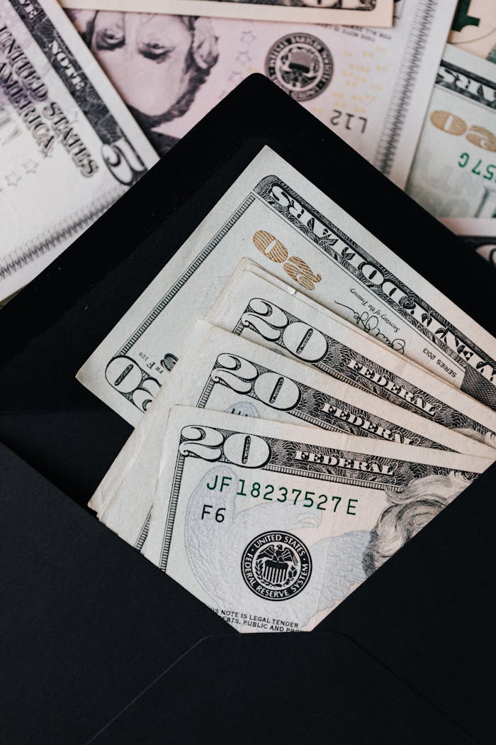 Stack of dollars and black envelope with banknotes inside